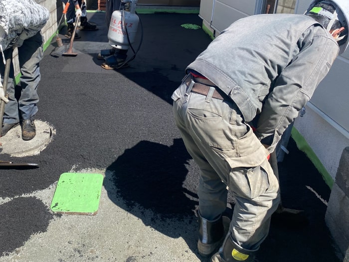 北区玄関前通路ロードヒーティング工事(アスファルト舗装敷設作業中)